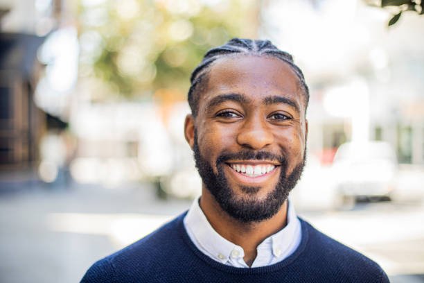 An attractive young black man in business attire outdoors